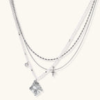 Multi-strand layered necklace set with silver chains, white pearls, star charm, heart pendant, and ornate decorative piece