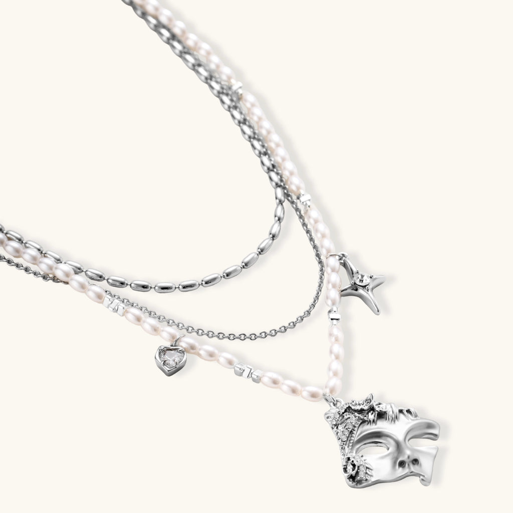 Multi-strand layered necklace set with silver chains, white pearls, star charm, heart pendant, and ornate decorative piece