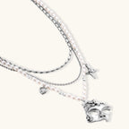 Multi-strand layered necklace set with silver chains, white pearls, star charm, heart pendant, and ornate decorative piece