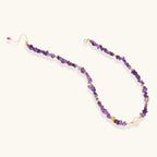 Beaded necklace with purple amethyst chips, freshwater pearls, and gold accents on white background.