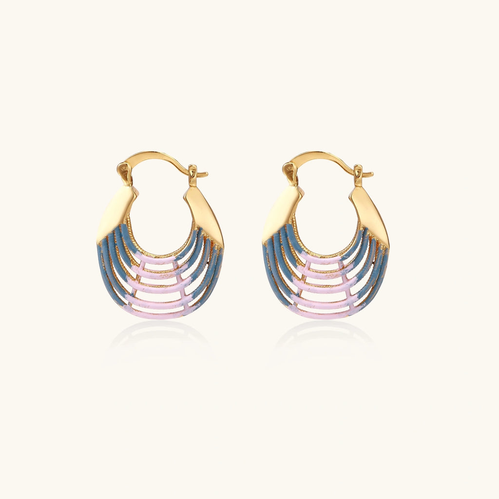 Gold hoop earrings with gradient blue-to-pink enamel in ribbed fan design on beige background