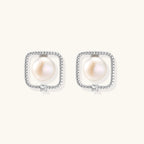 Rhodium-plated silver stud earrings with cushion frame, centered freshwater pearl, and tiny crystal accent