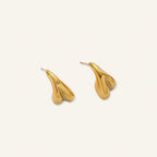 Organic sculptural gold stud earrings with fluid matte finish on cream background