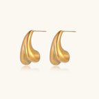 Organic sculptural gold stud earrings with fluid matte finish on cream background