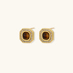 Gold-plated octagonal stud earrings with brown tiger's eye centers and cubic zirconia border on cream background.
