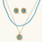 Gold-plated turquoise jewelry set with circular medallion pendant, beaded necklace, and matching stud earrings on white background
