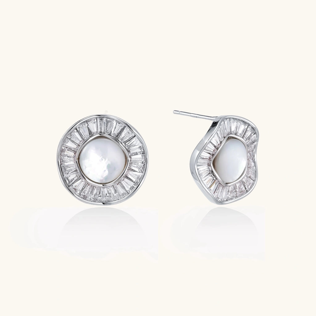 White gold-plated stud earrings with iridescent pearl centers surrounded by baguette crystal halos on white background.