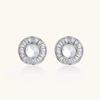 White gold-plated stud earrings with iridescent pearl centers surrounded by baguette crystal halos on white background.