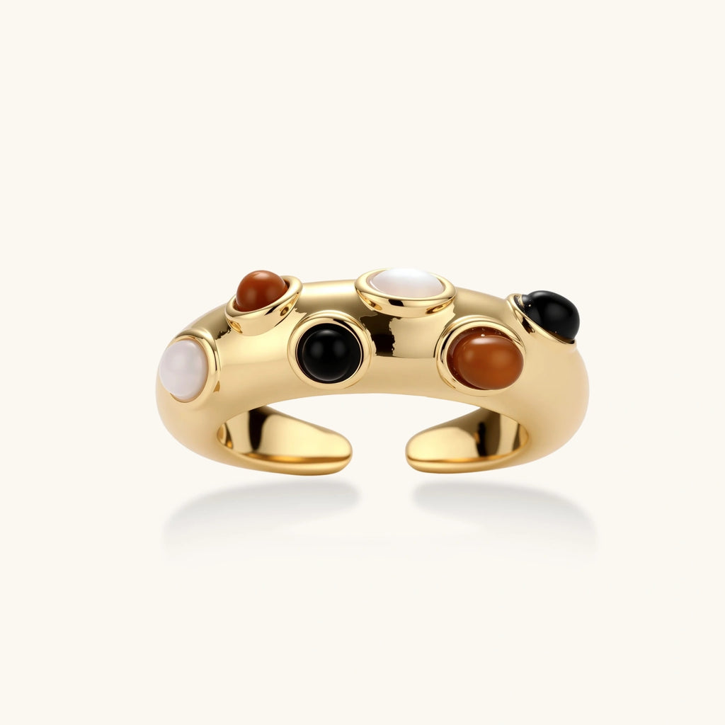 Gold-plated adjustable ring with white, amber, and black stones in organic bubble design on neutral background.