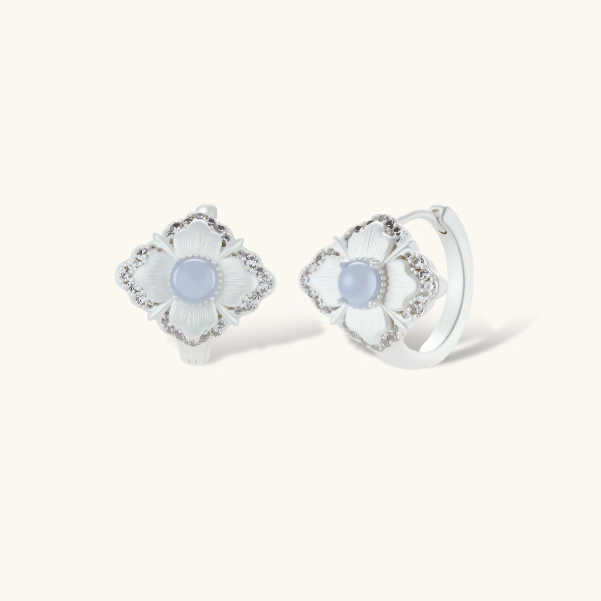 Silver-plated flower earrings with blue zirconia centers, featuring one stud and one huggie hoop in mismatched pair style.