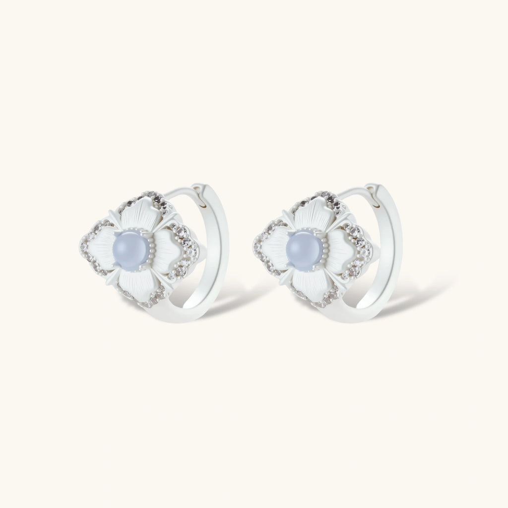 Silver-plated flower earrings with blue zirconia centers, featuring one stud and one huggie hoop in mismatched pair style.