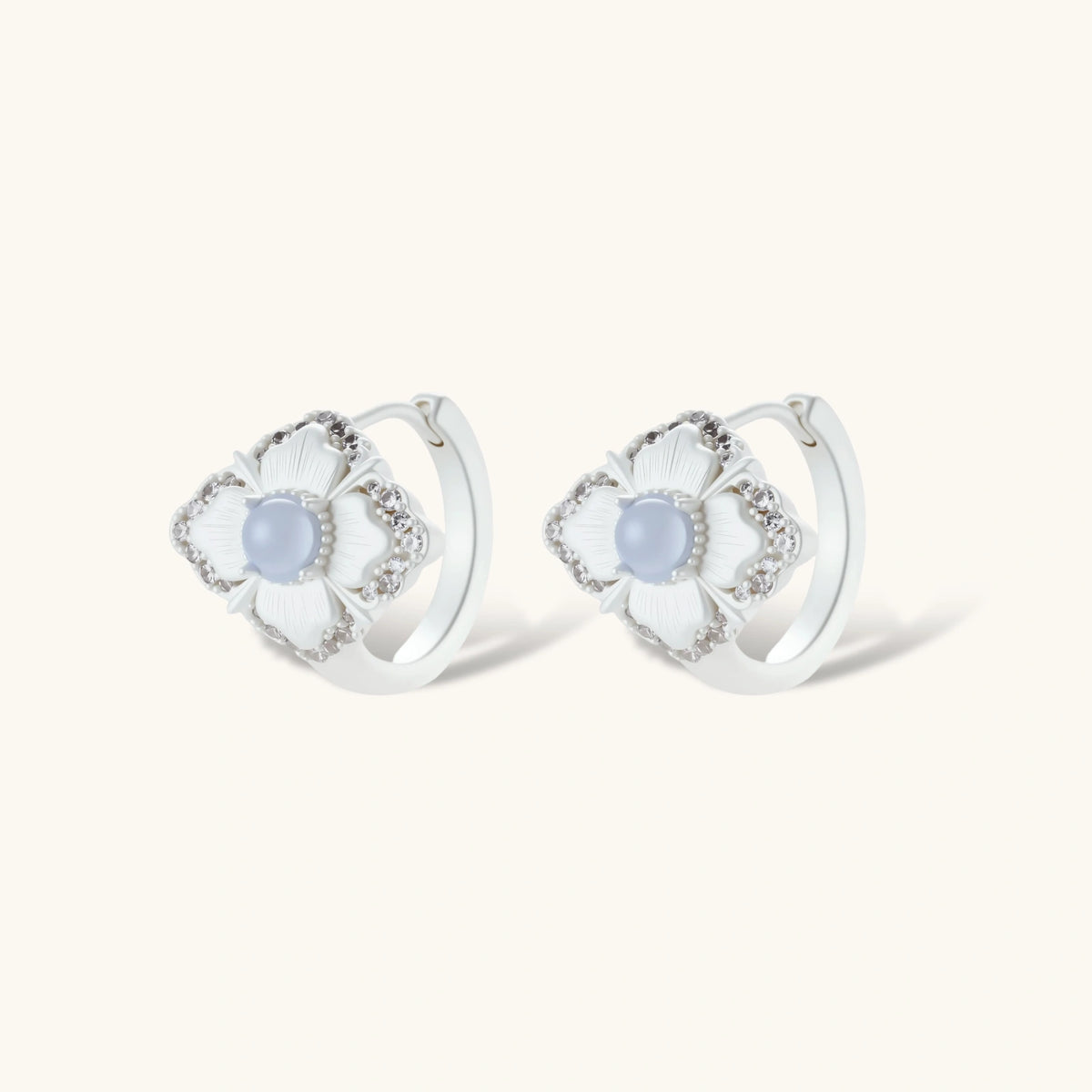 Silver-plated flower earrings with blue zirconia centers, featuring one stud and one huggie hoop in mismatched pair style.