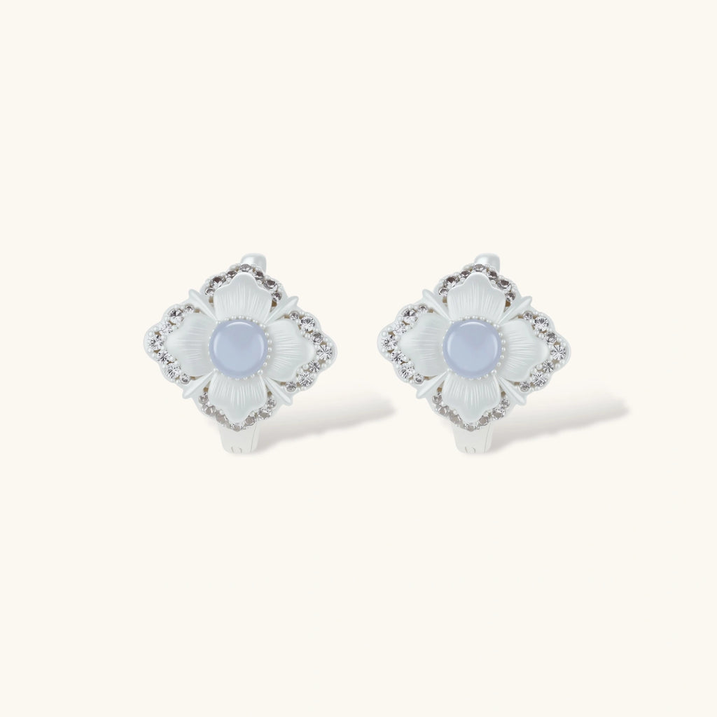 Silver-plated flower earrings with blue zirconia centers, featuring one stud and one huggie hoop in mismatched pair style.