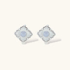 Silver-plated flower earrings with blue zirconia centers, featuring one stud and one huggie hoop in mismatched pair style.