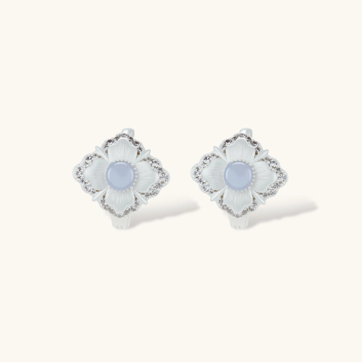 Silver-plated flower earrings with blue zirconia centers, featuring one stud and one huggie hoop in mismatched pair style.