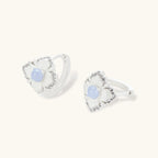 Silver-plated flower earrings with blue zirconia centers, featuring one stud and one huggie hoop in mismatched pair style.