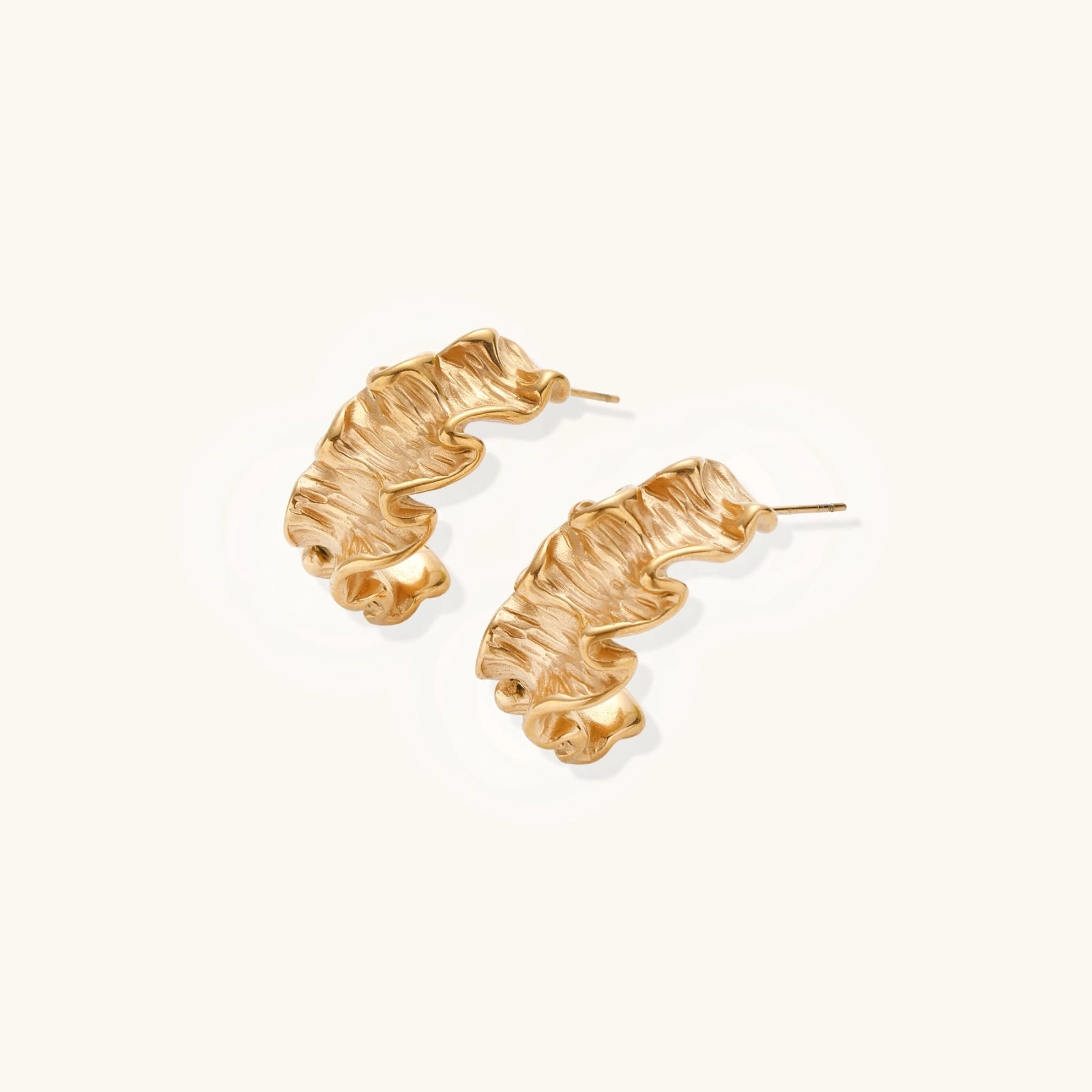 Sculptural gold hoops with textured wave patterns and rippled surface in 14K plating, shown from front and back angles
