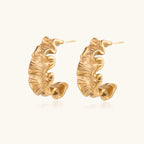 Sculptural gold hoops with textured wave patterns and rippled surface in 14K plating, shown from front and back angles