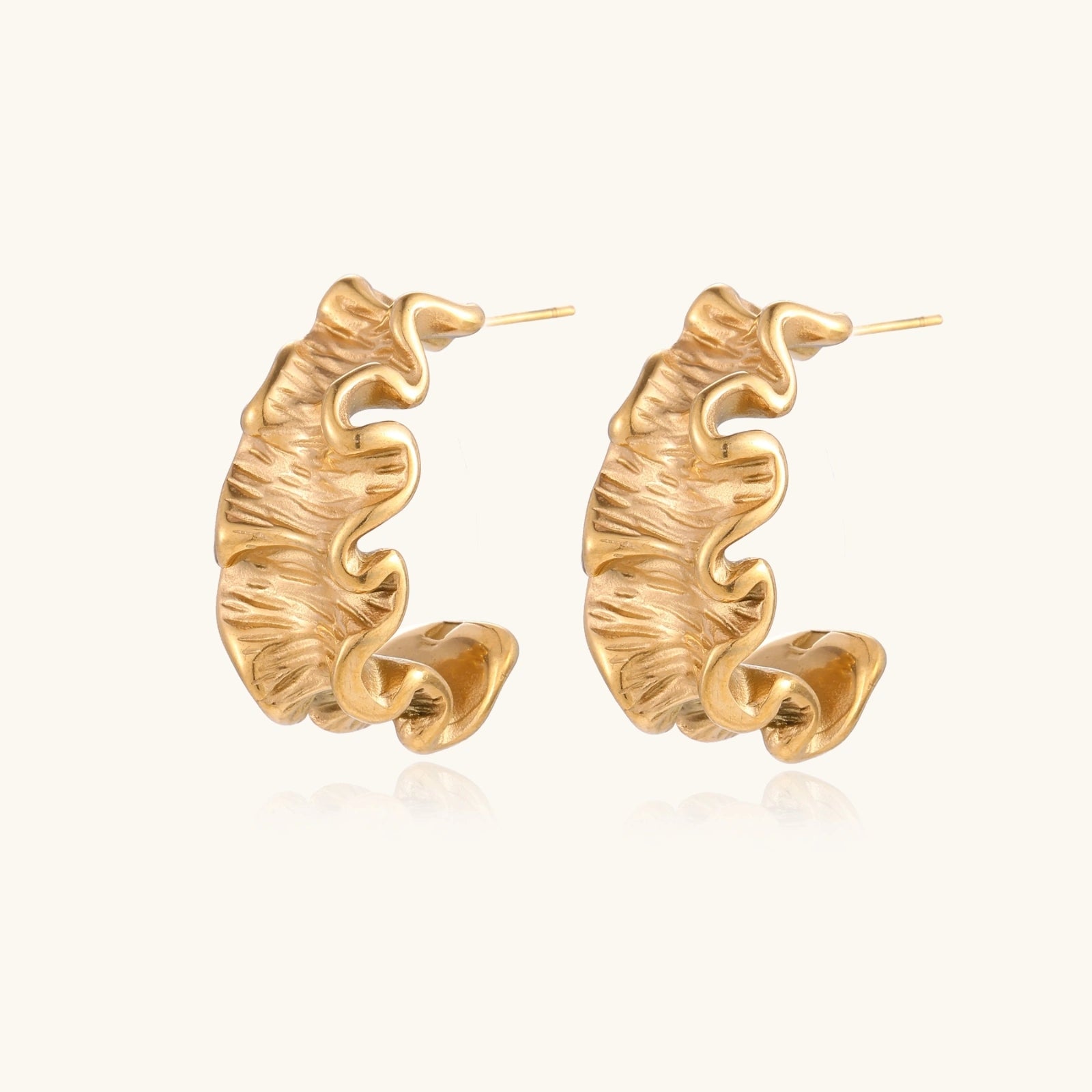 Sculptural gold hoops with textured wave patterns and rippled surface in 14K plating, shown from front and back angles